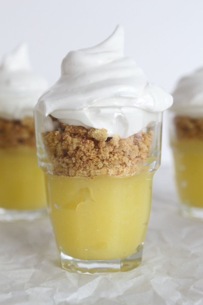 close up side view of lemon curd, graham cracker crust, and meringue layered in a shot glass