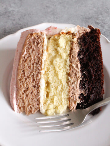 slice of 3 layer neapolitan cake on a white plate