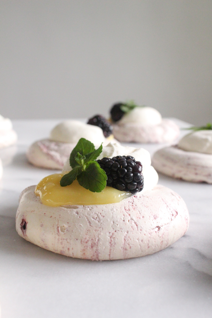 side view of meringue topped with lemon curd and blackberry