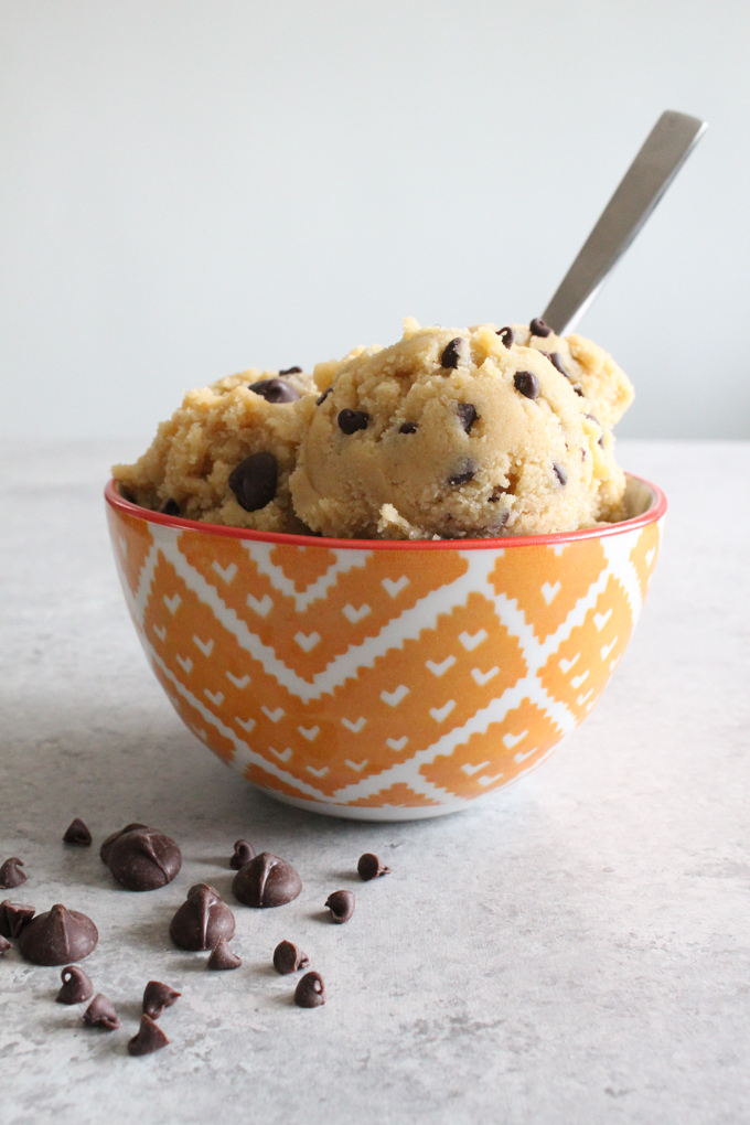 Side view of cookie dough in an orange bowl.