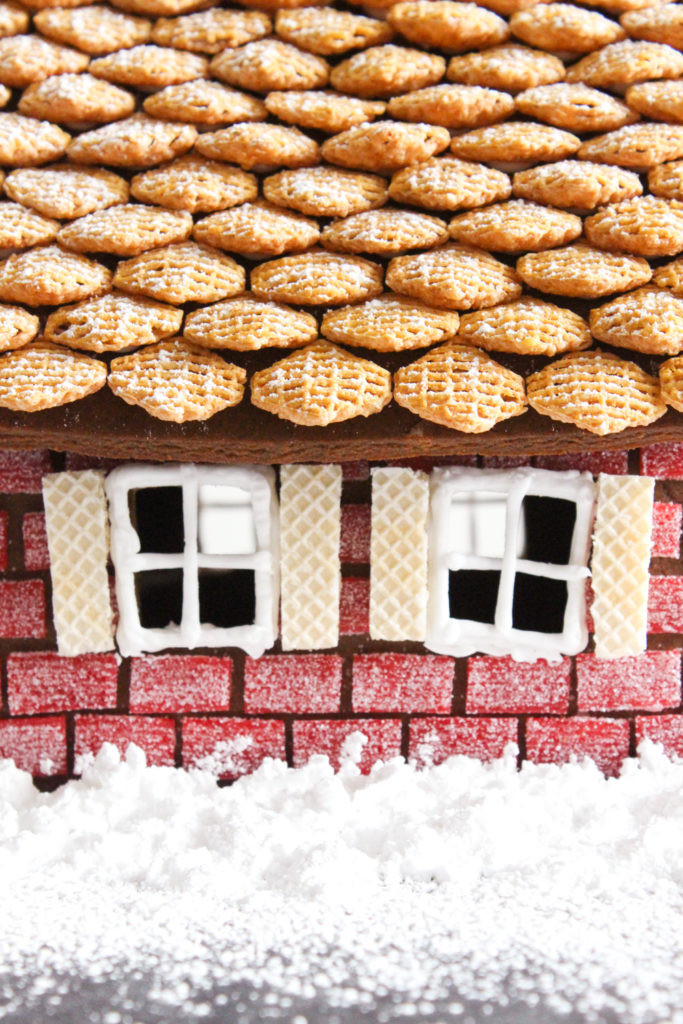 Side view of gingerbread house with a cereal roof and wafer cookie window shingles.