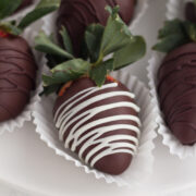 overhead view of chocolate covered strawberries with white chocolate drizzle on a white plate