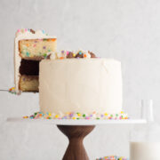 side view of funfetti layer cake with a slice being lifted up