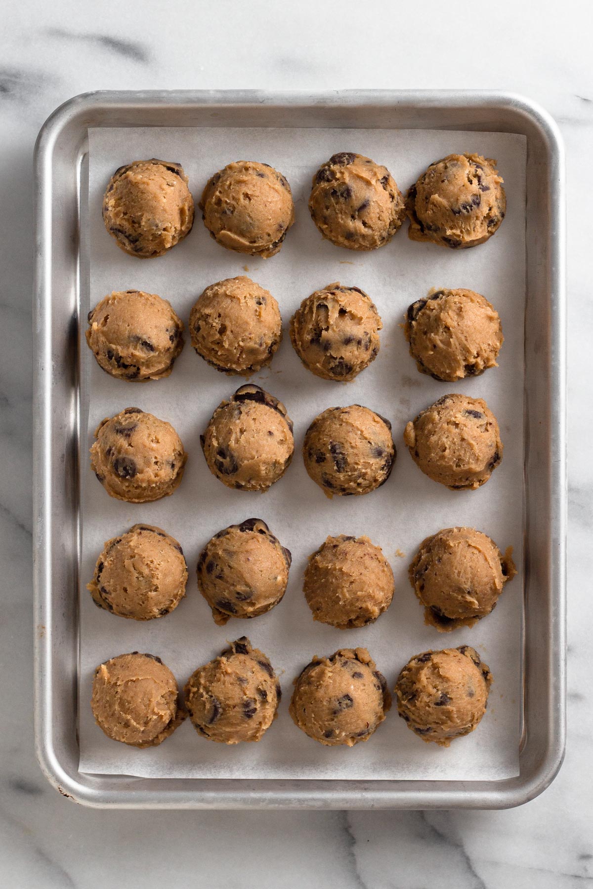 overhead view of cookie dough balls on a baking sheet