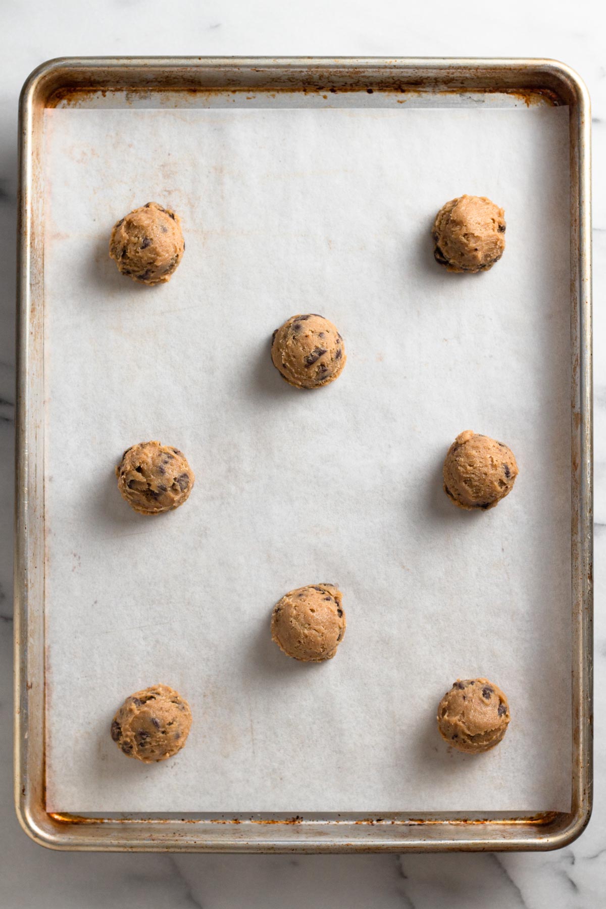 overhead view of cookie dough balls on a baking sheet