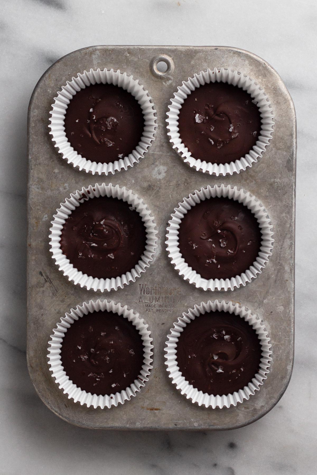 Overhead view of peanut butter cups in muffin pan.