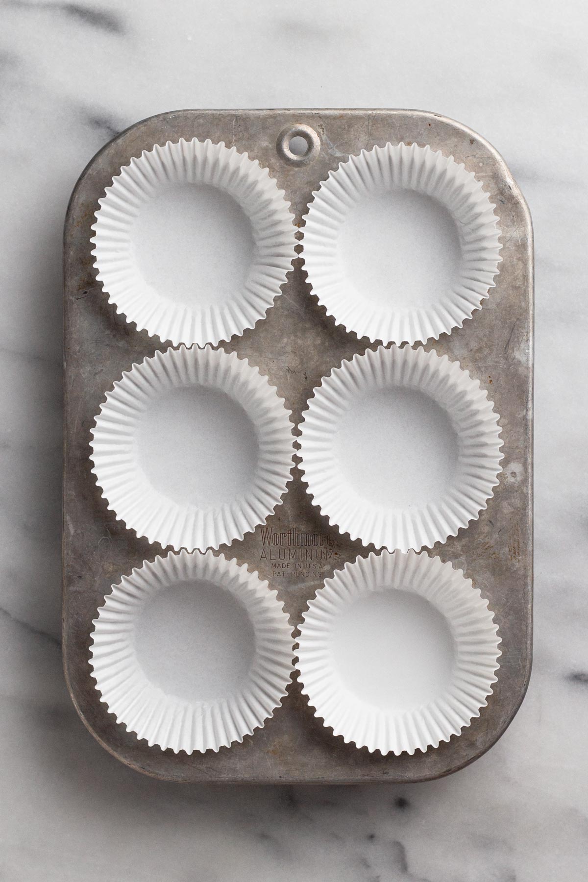 Overhead view of muffin pan with paper liners.