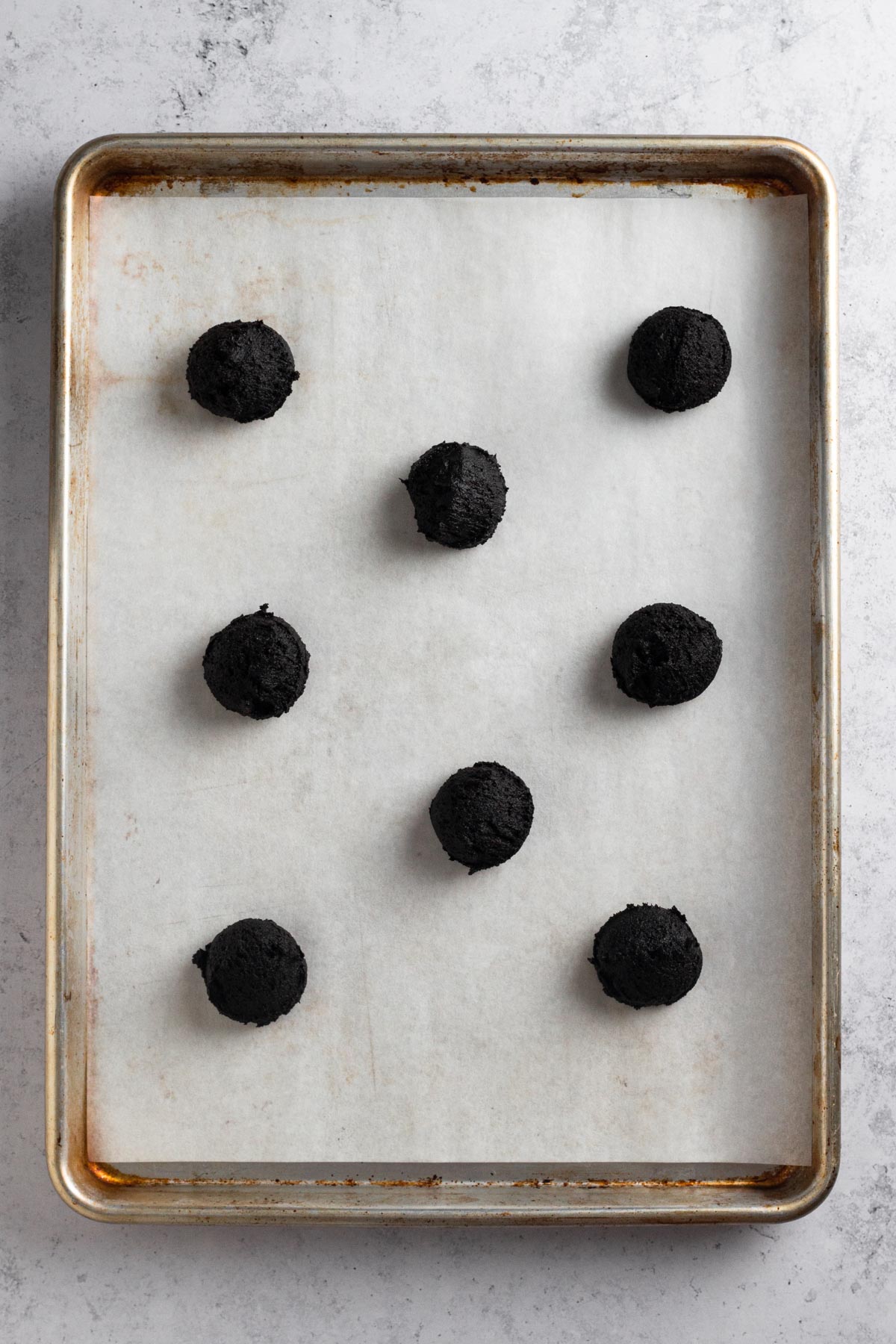 Overhead view of cookie dough balls on a baking sheet.