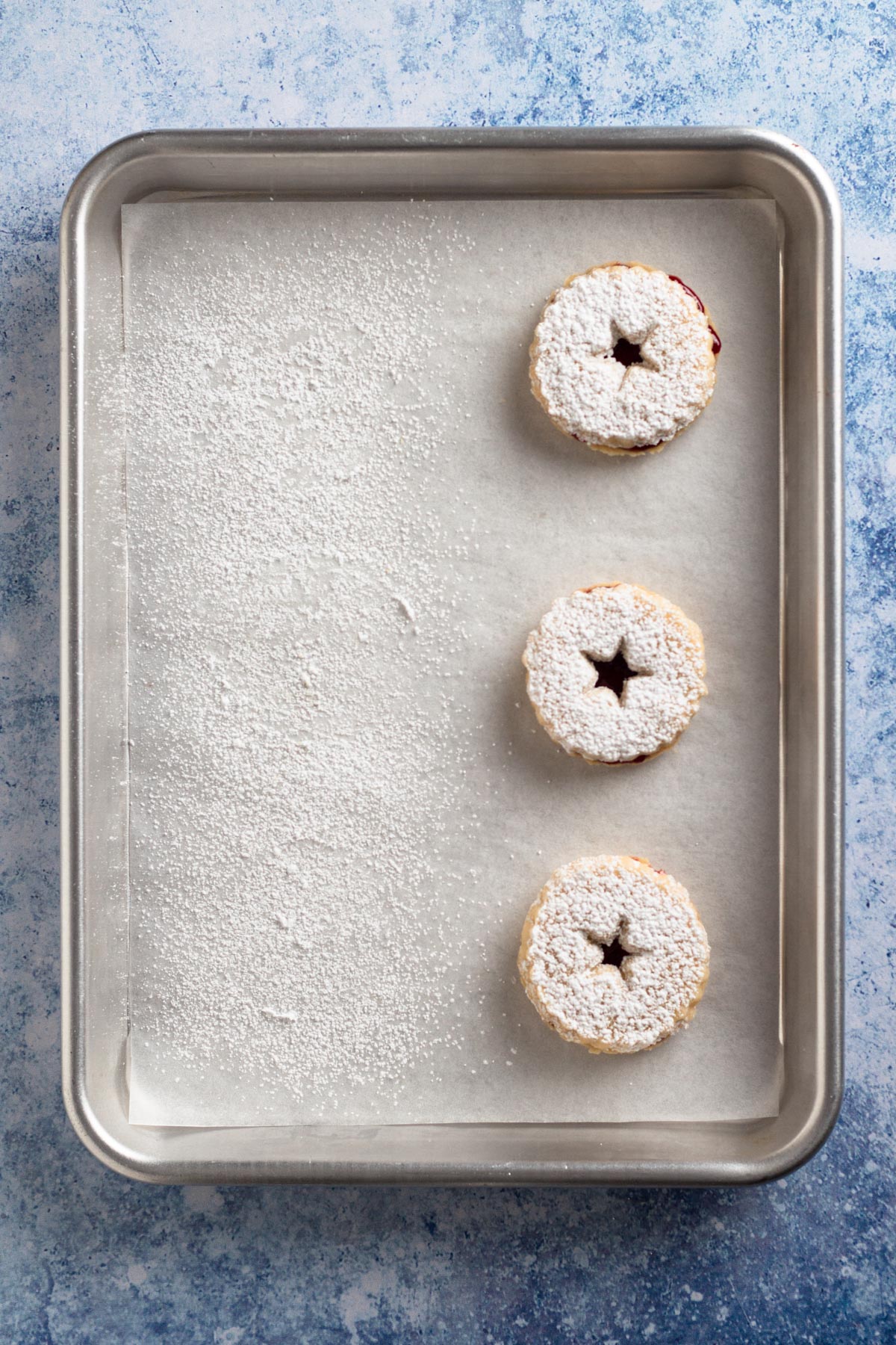 Overhead view of assembled cookie sandwiches on a baking sheet.