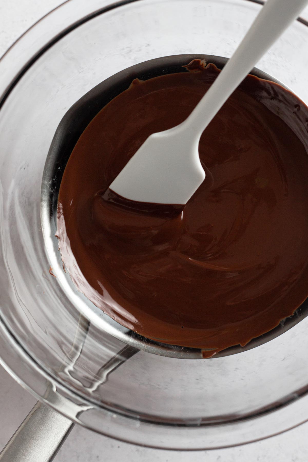 overhead view of melted chocolate in double boiler with spatula