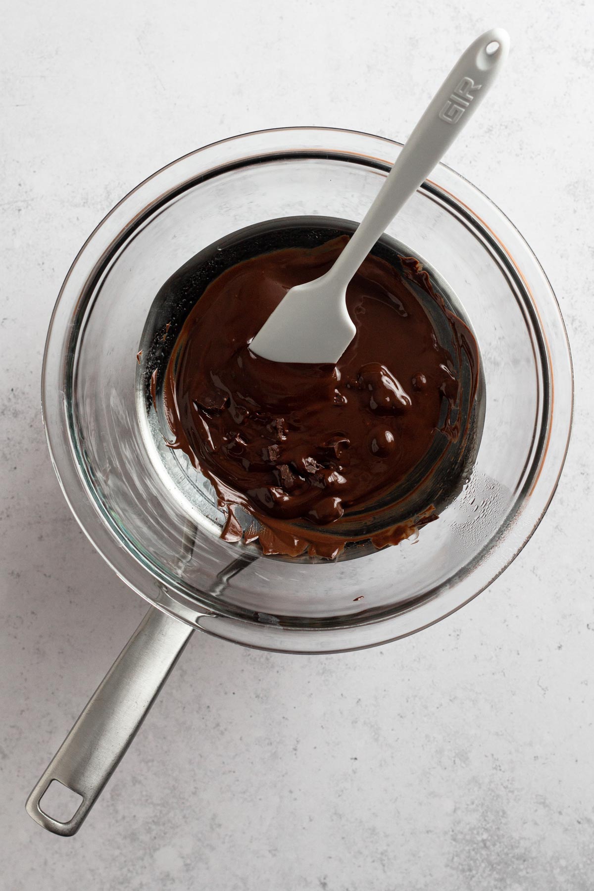overhead view of melting chocolate in double boiler with spatula