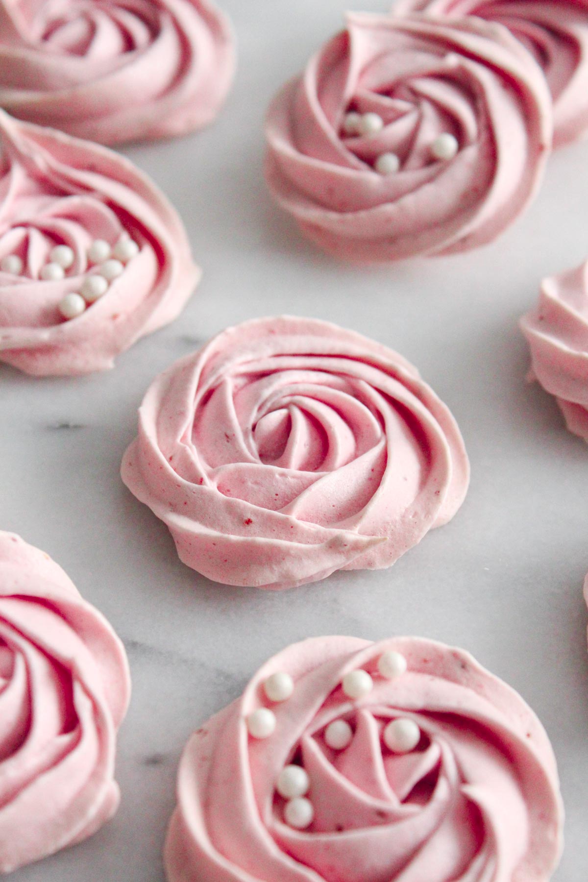 angled view of meringue cookies on a marble surface