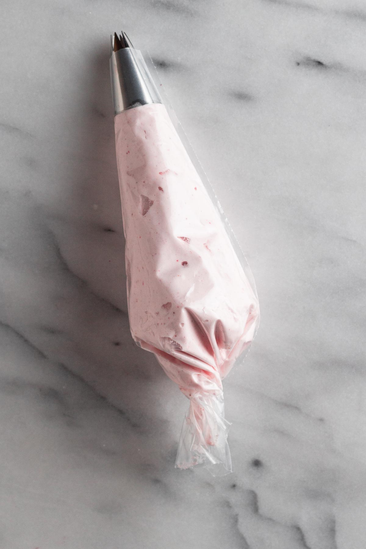 pink meringue in a piping bag with a star piping tip