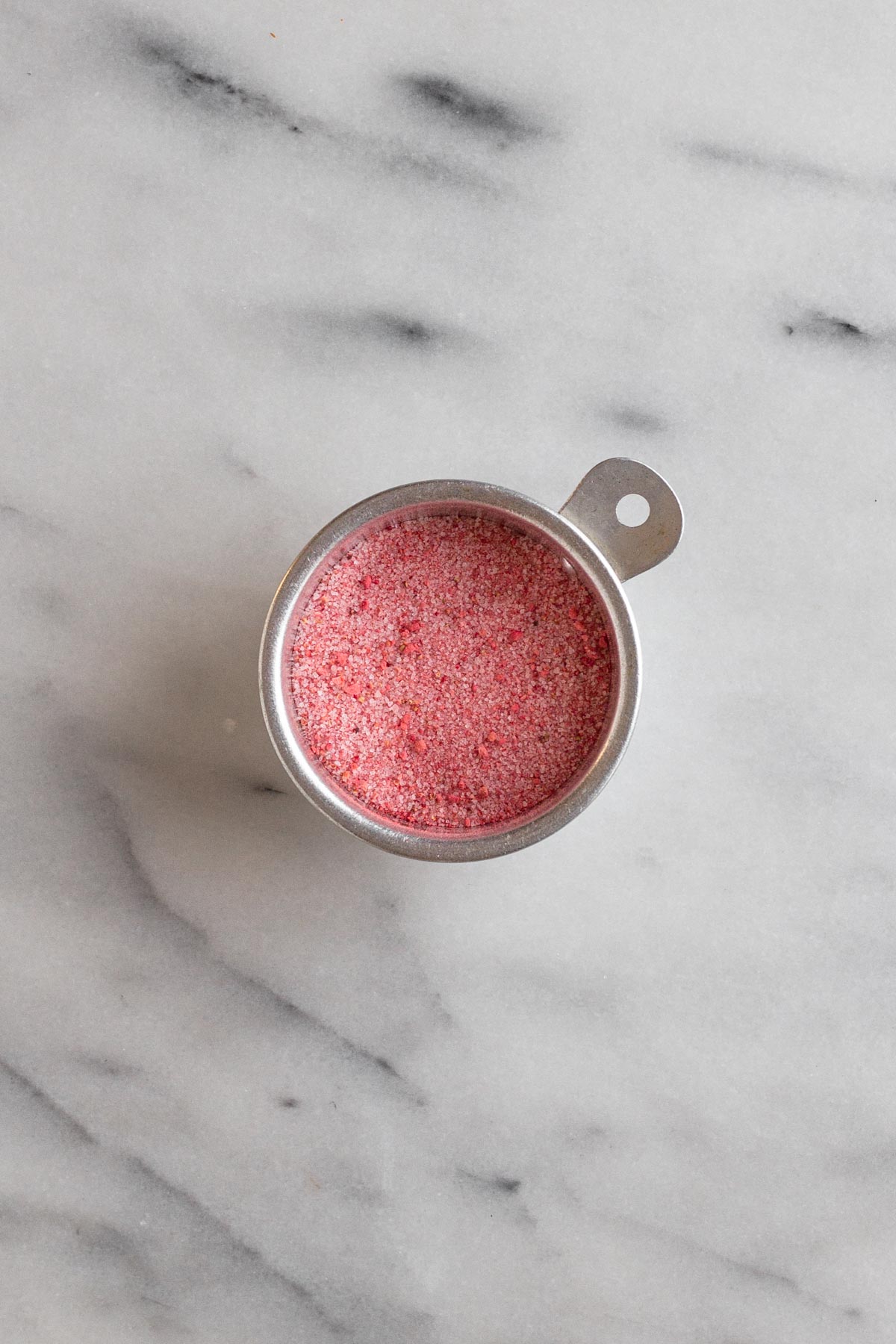 sugar and powdered freeze-dried strawberries in a metal cup