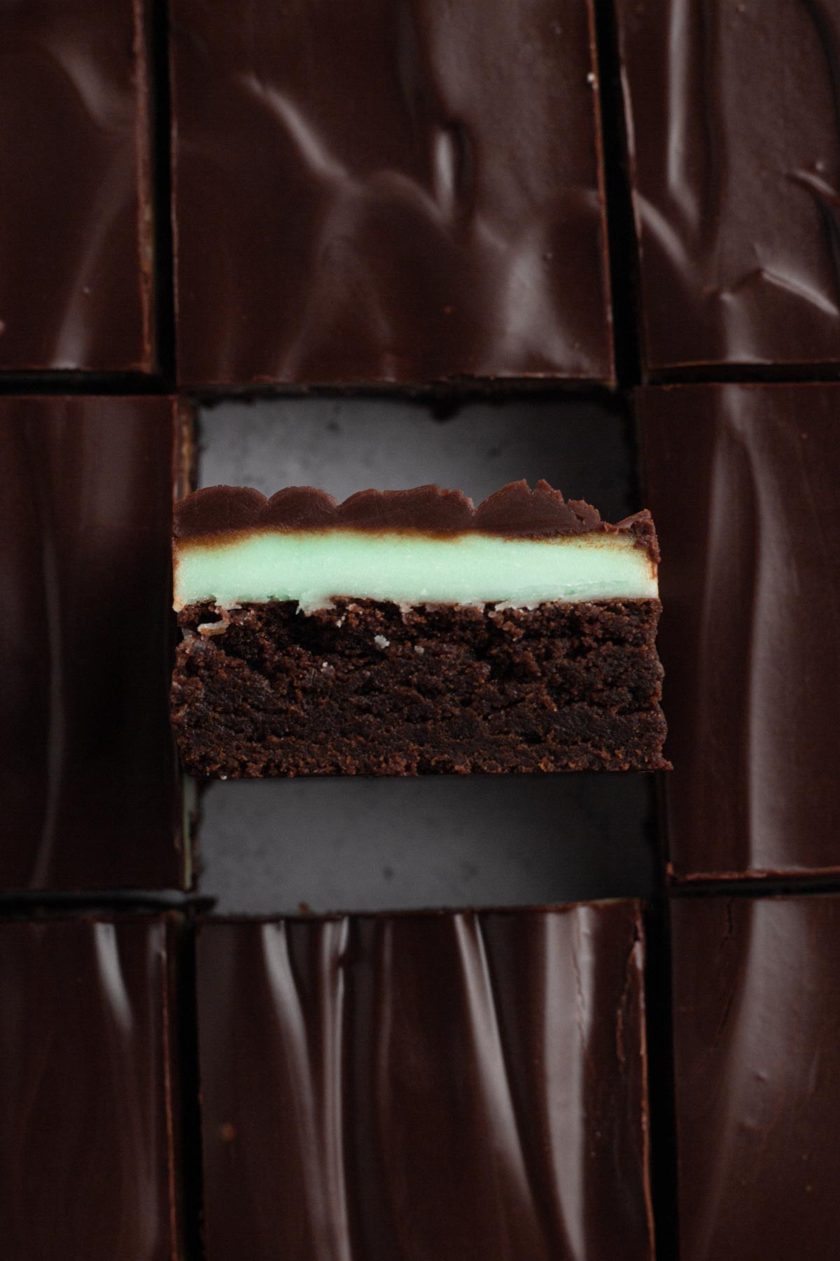 overhead view of sliced brownies with one turned sideways with the mint and chocolate layers visible