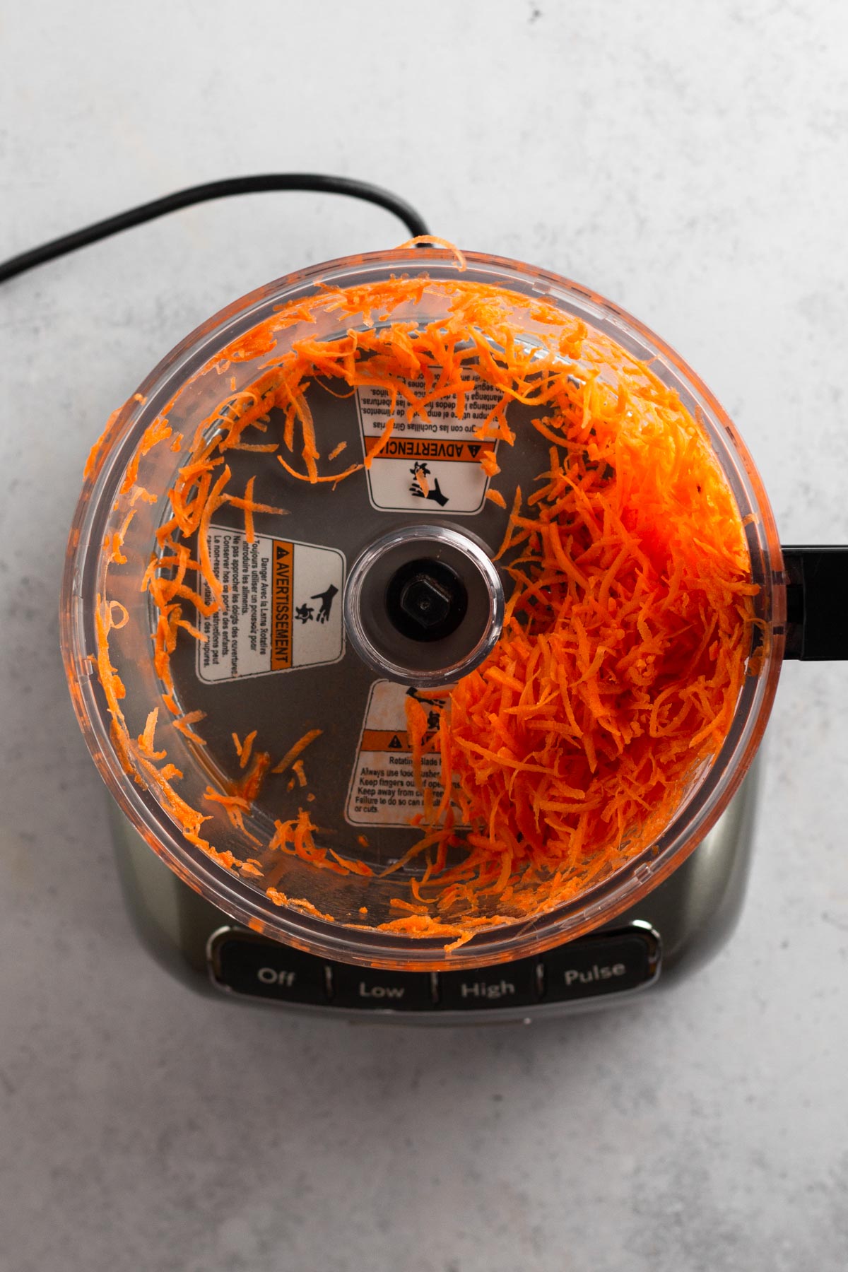 shredded carrots in work bowl of food processor