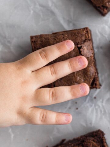 Toddler hand reaching for a brownie.