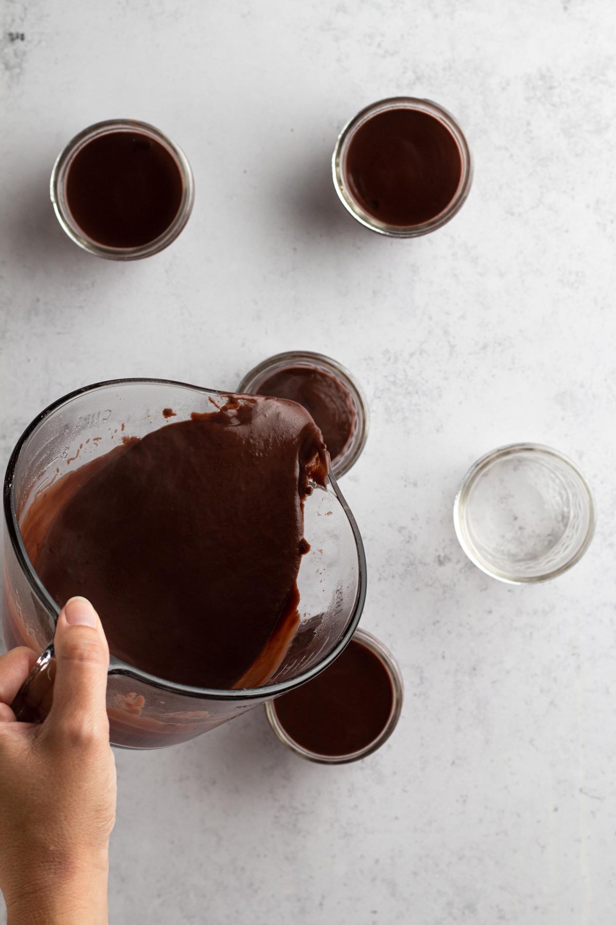 Pouring pudding into jars.