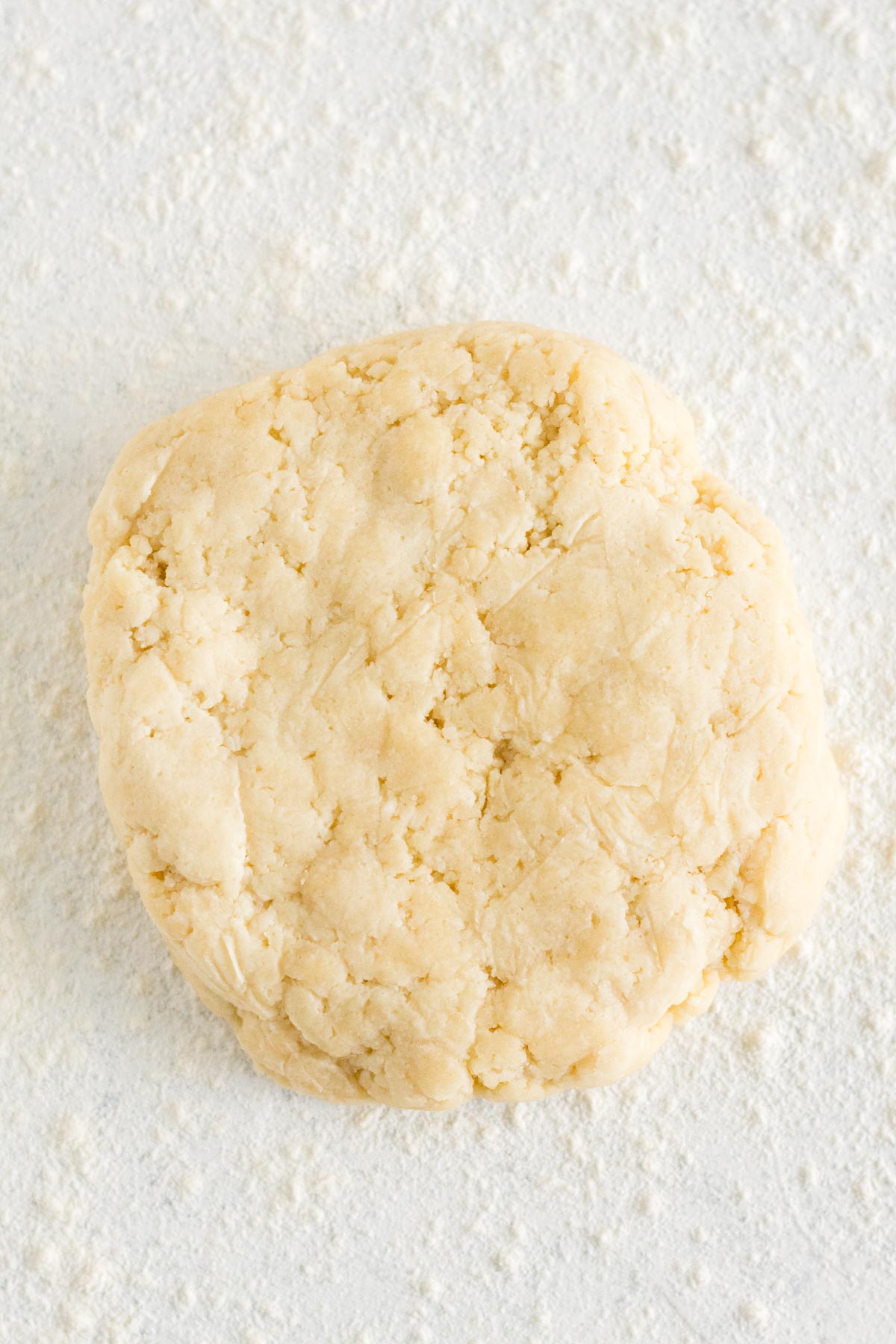 Pie crust dough on a white, floured surface.
