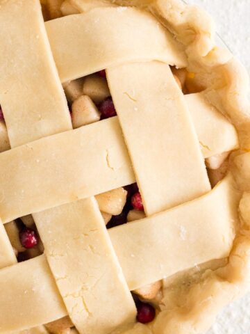Unbaked lattice pie on a white surface.