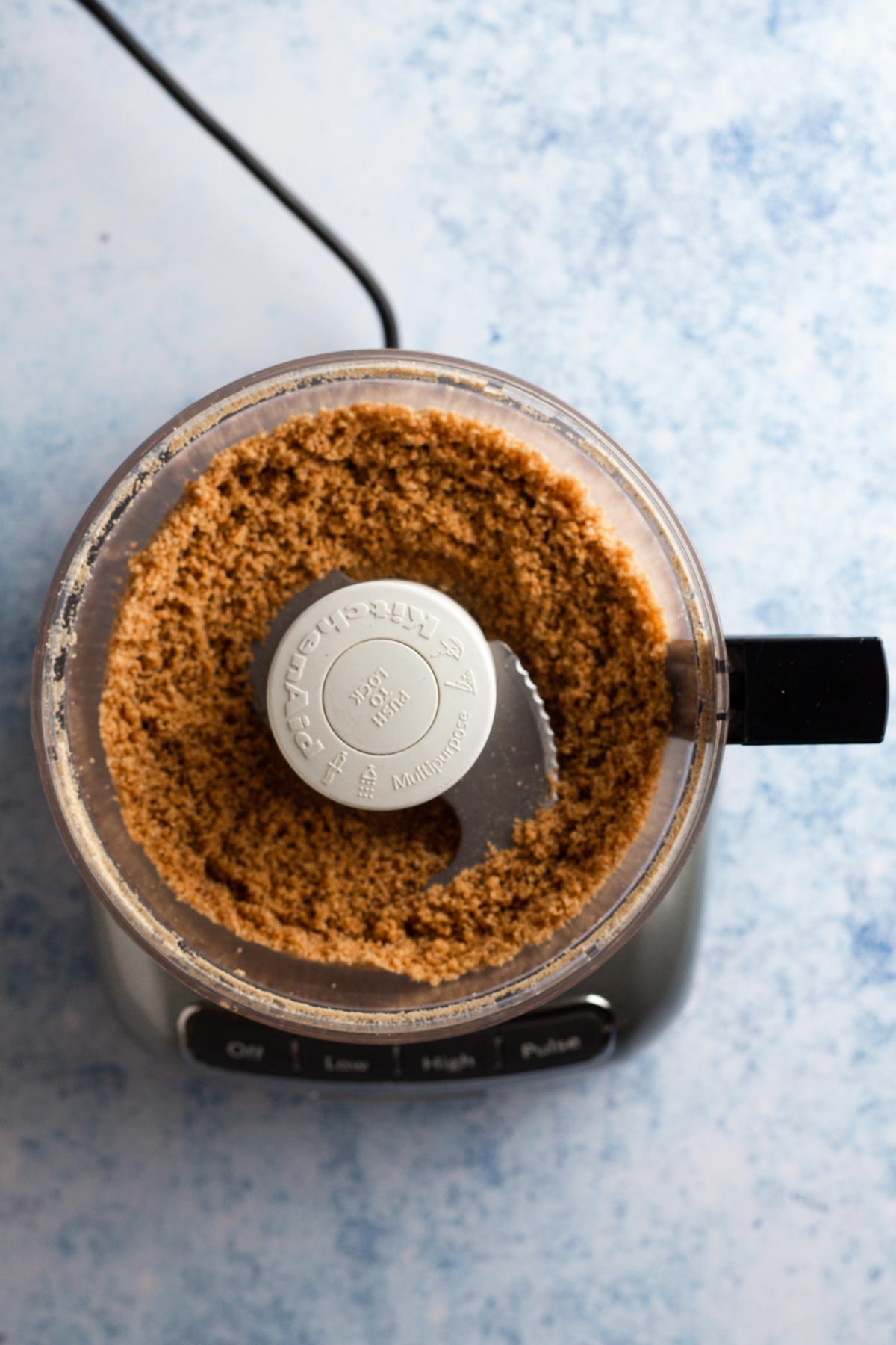 Graham cracker crust in the bowl of a food processor.