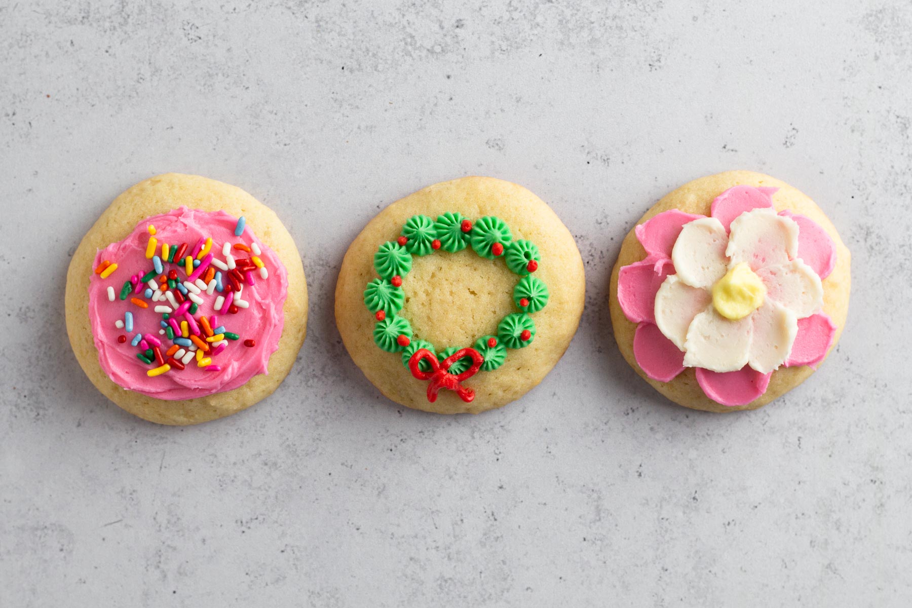 Frosted sugar cookies on a greay surface