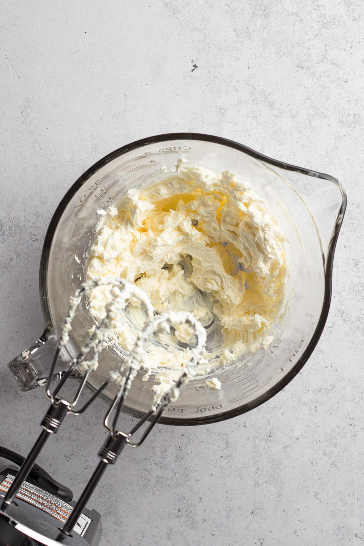 Cream cheese beaten in a glass mixing bowl.