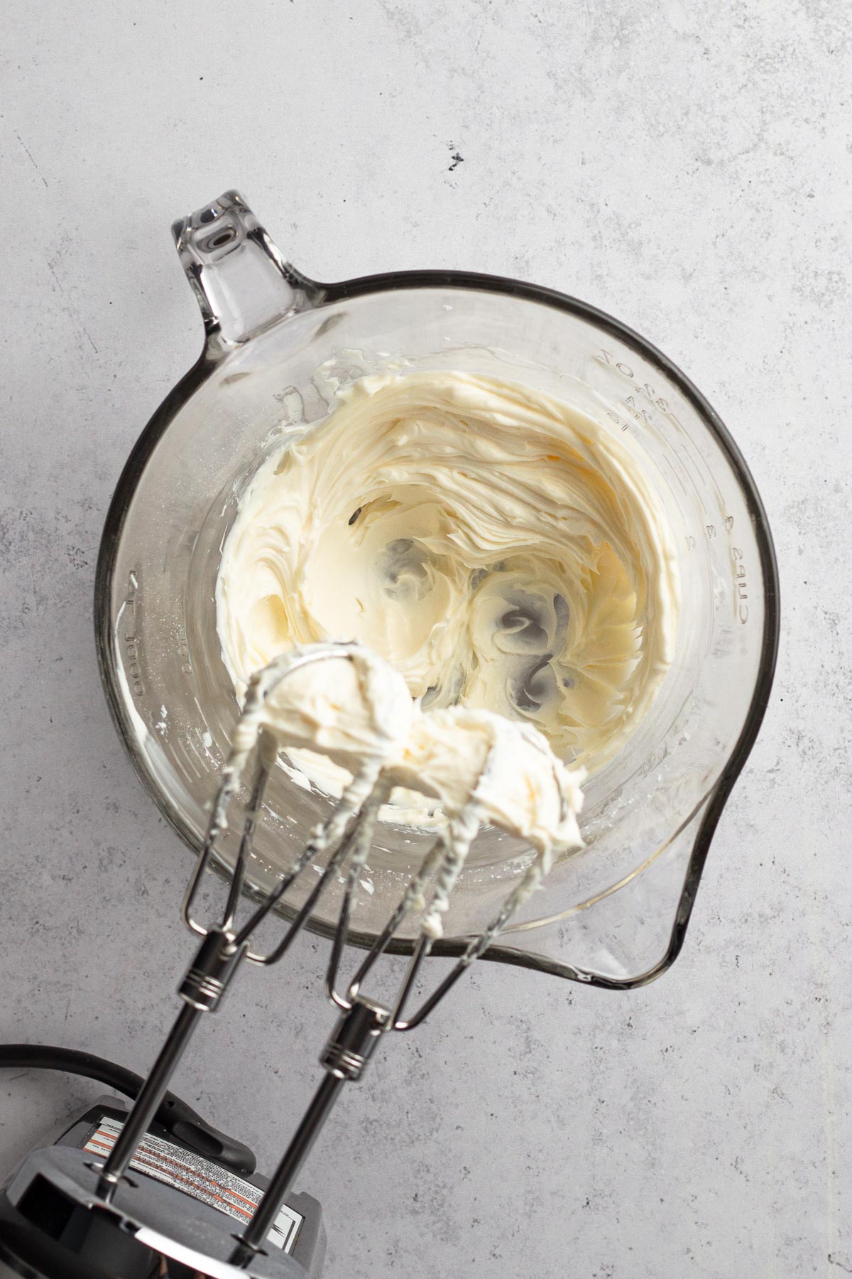 Cream cheese mixture blended in a glass mixing bowl.