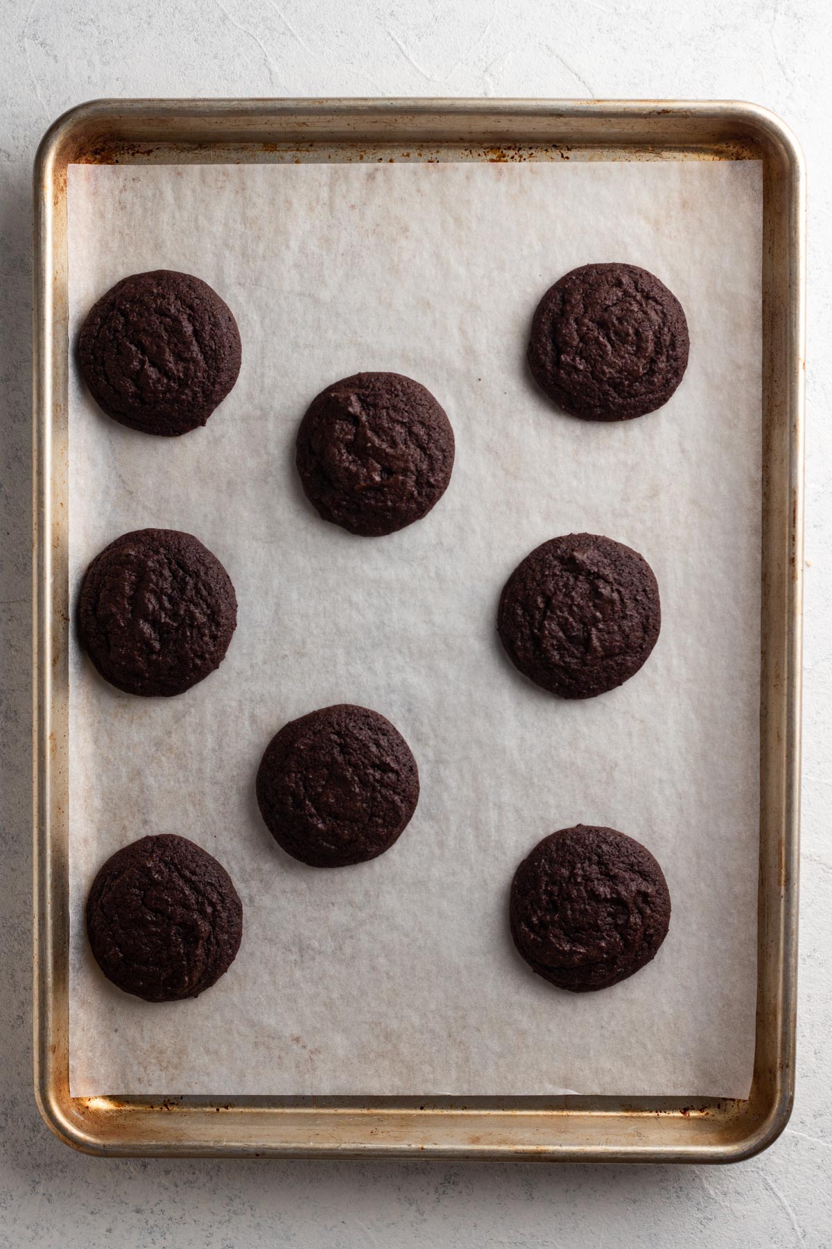 Baked chocolate peppermint cookies on a baking sheet lined with parchment paper.