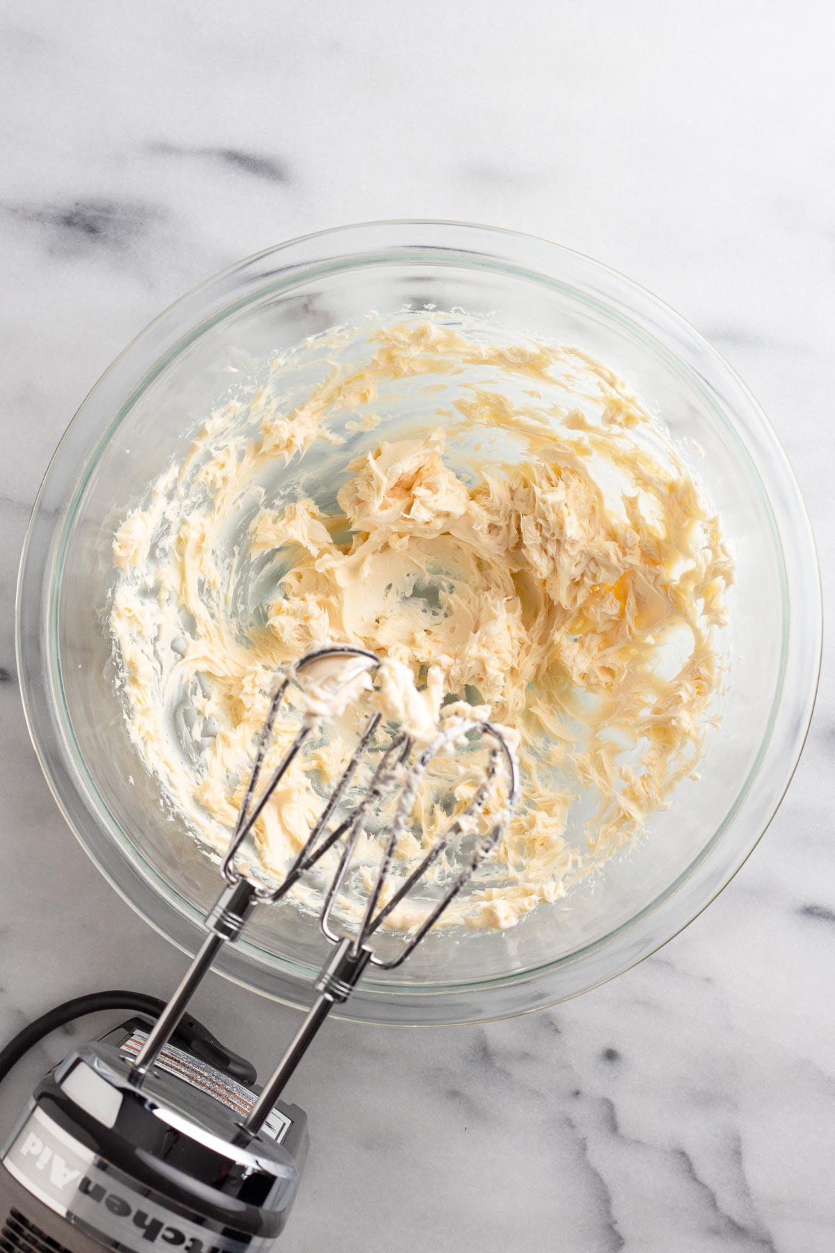 Butter, vanilla, and salt beaten together in a glass mixing bowl.