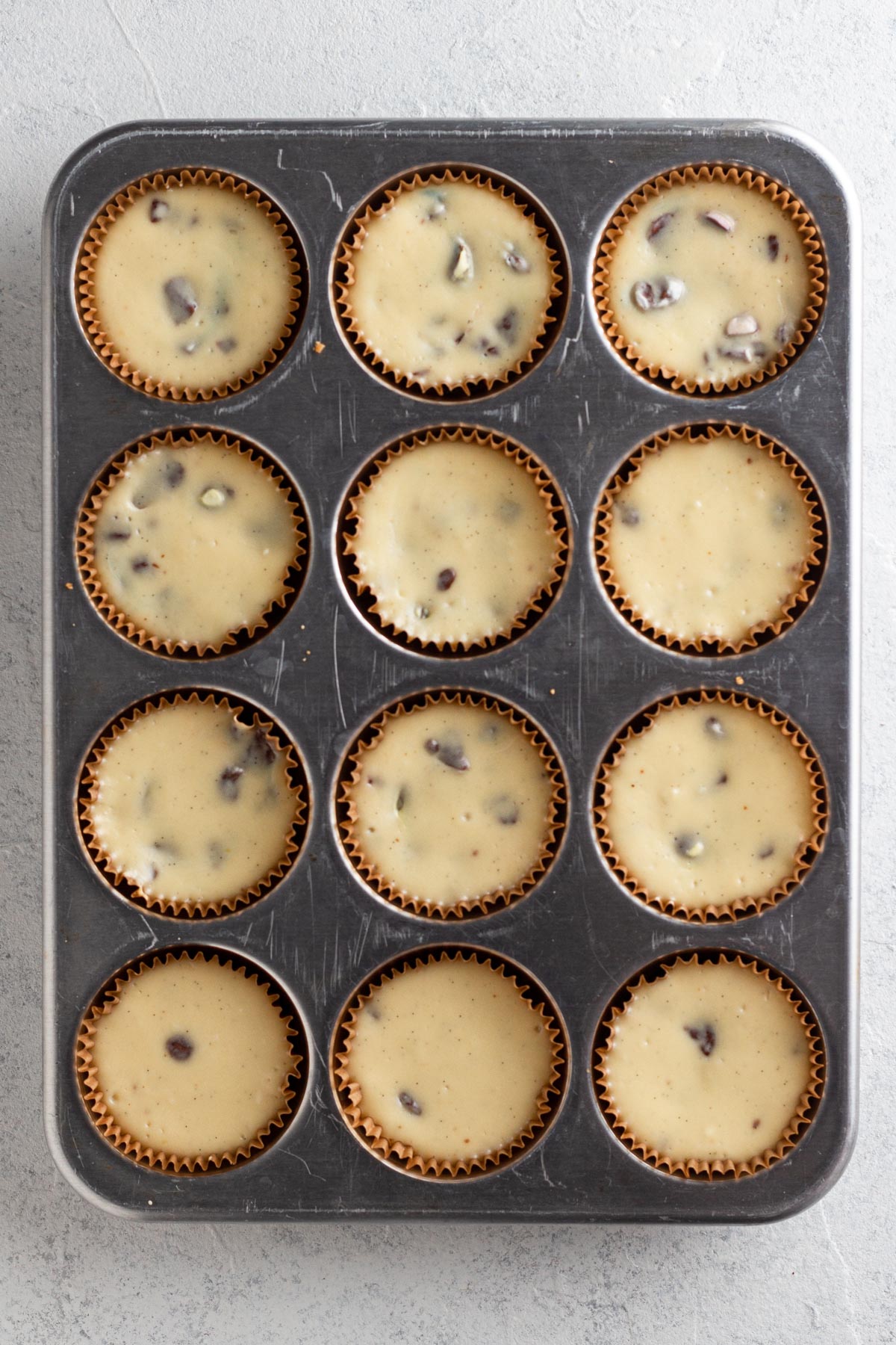 Baked mini cheesecakes in a muffin pan.