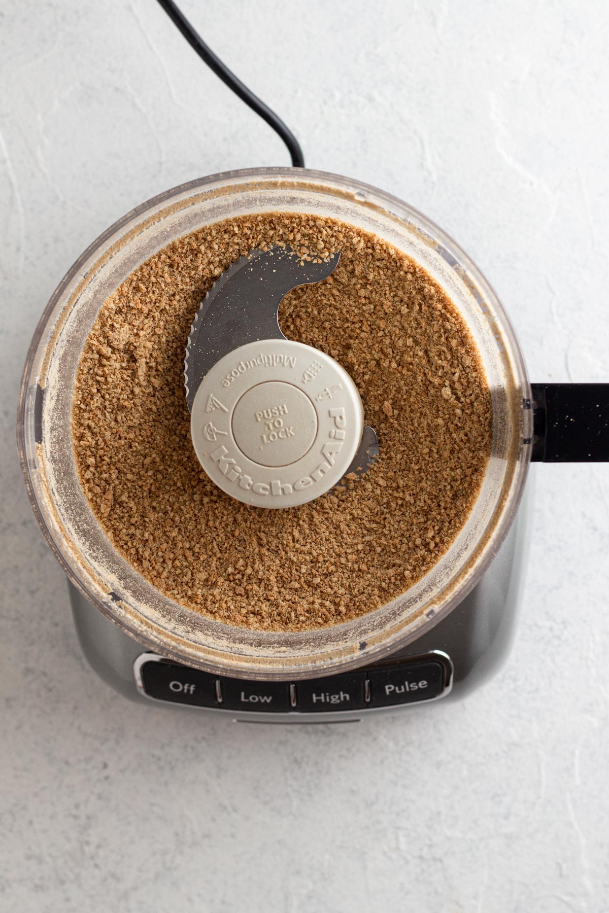 Graham cracker crumbs and sugar blended in the bowl of a food processor.