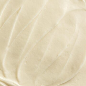 Close up view of cream cheese frosting spread on a cake.