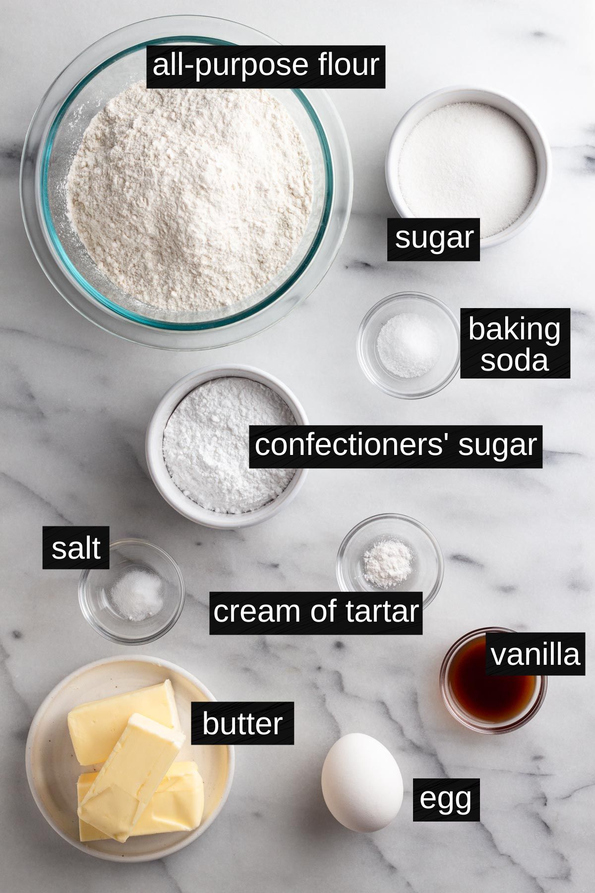 Recipe ingredients with labels on a marble surface.