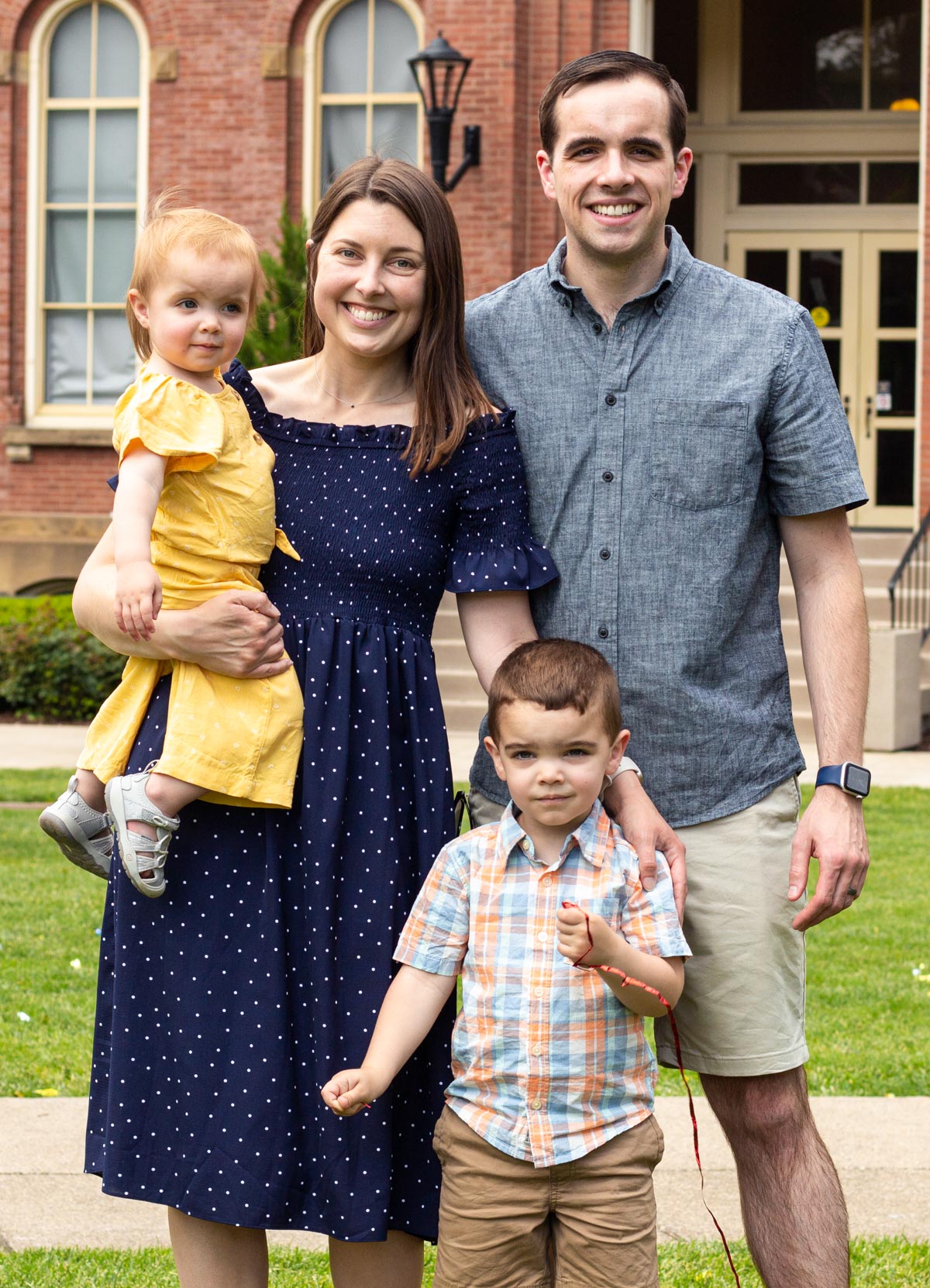 Allison standing in front of a brick building with her family.