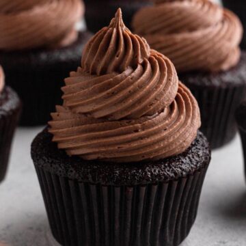 Chocolate frosting swirled on top of a chocolate cupcake.