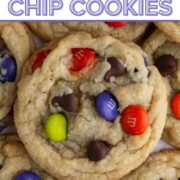 Stacked cookies with purple, orange, and green M&Ms and chocolate chips and a text overlay.