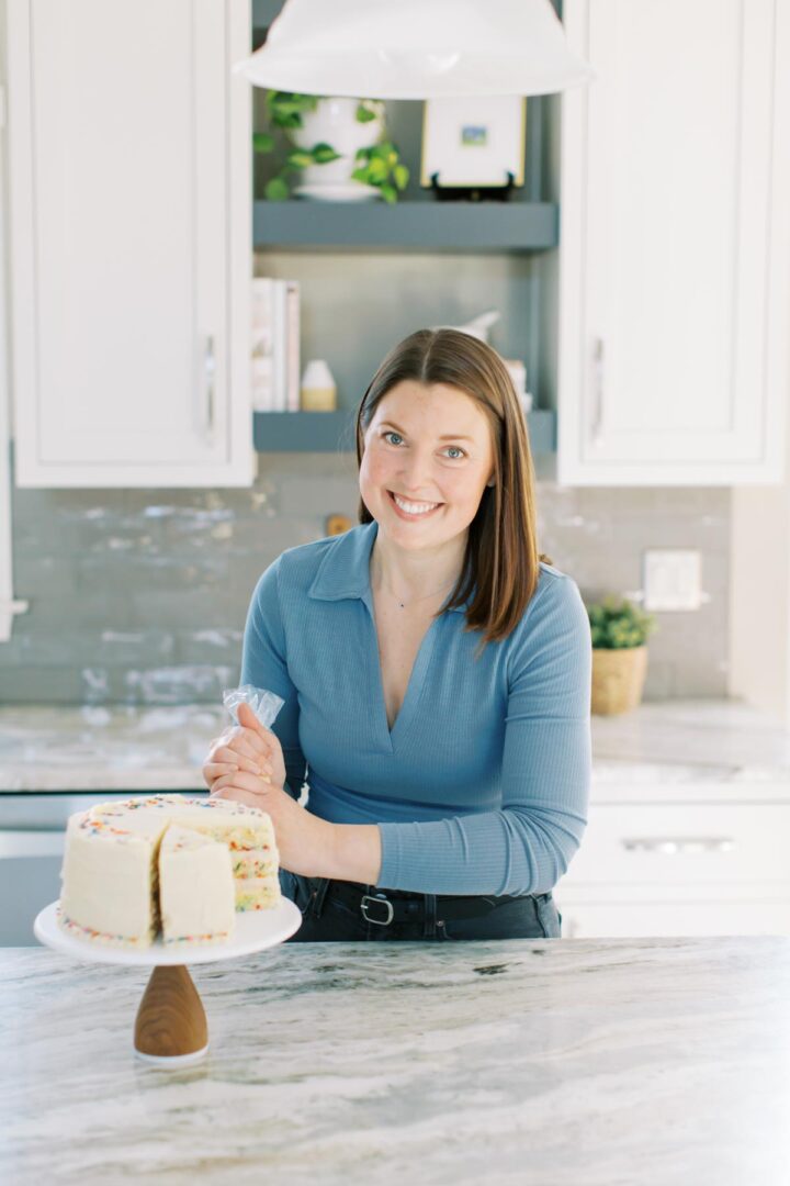 Allison piping frosting onto a cake.