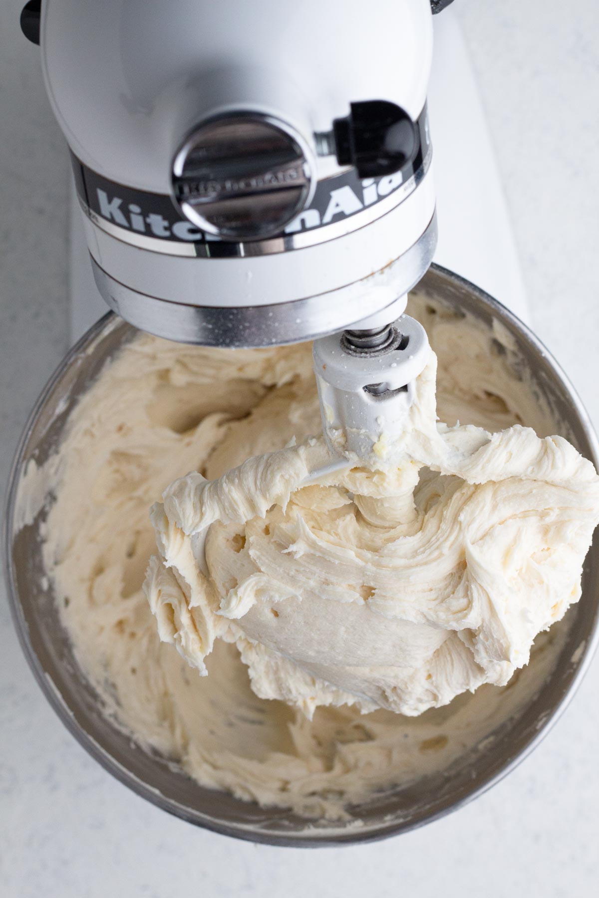 Vanilla frosting in the bowl of a stand mixer.