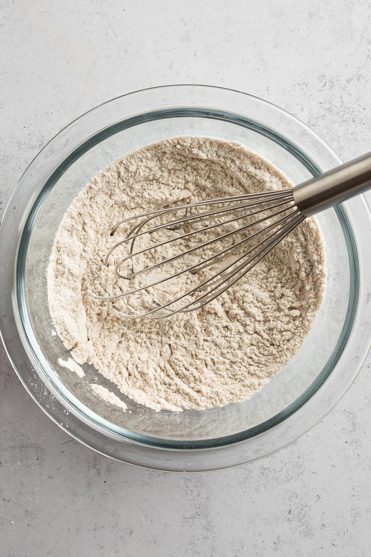 Dry ingredients whisked together in a glass bowl.