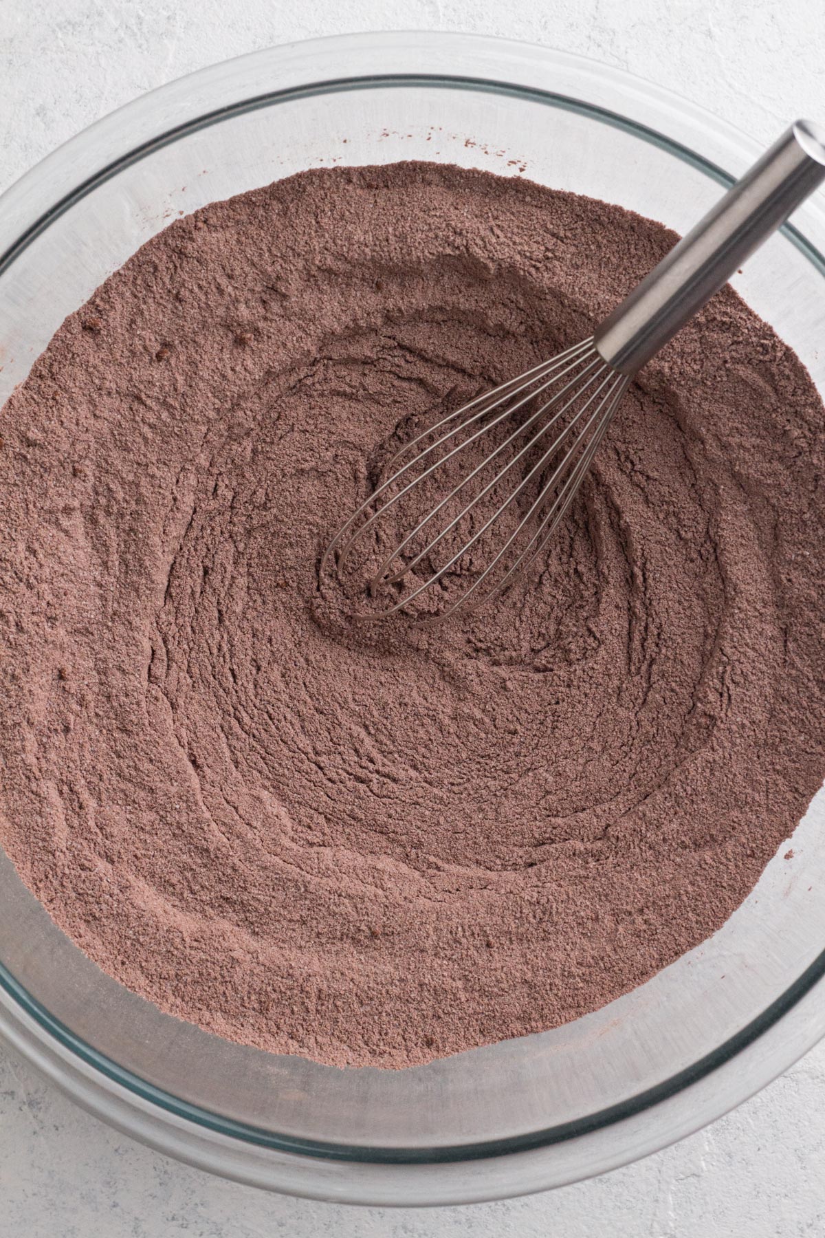 Dry ingredients whisked together in a glass mixing bowl.