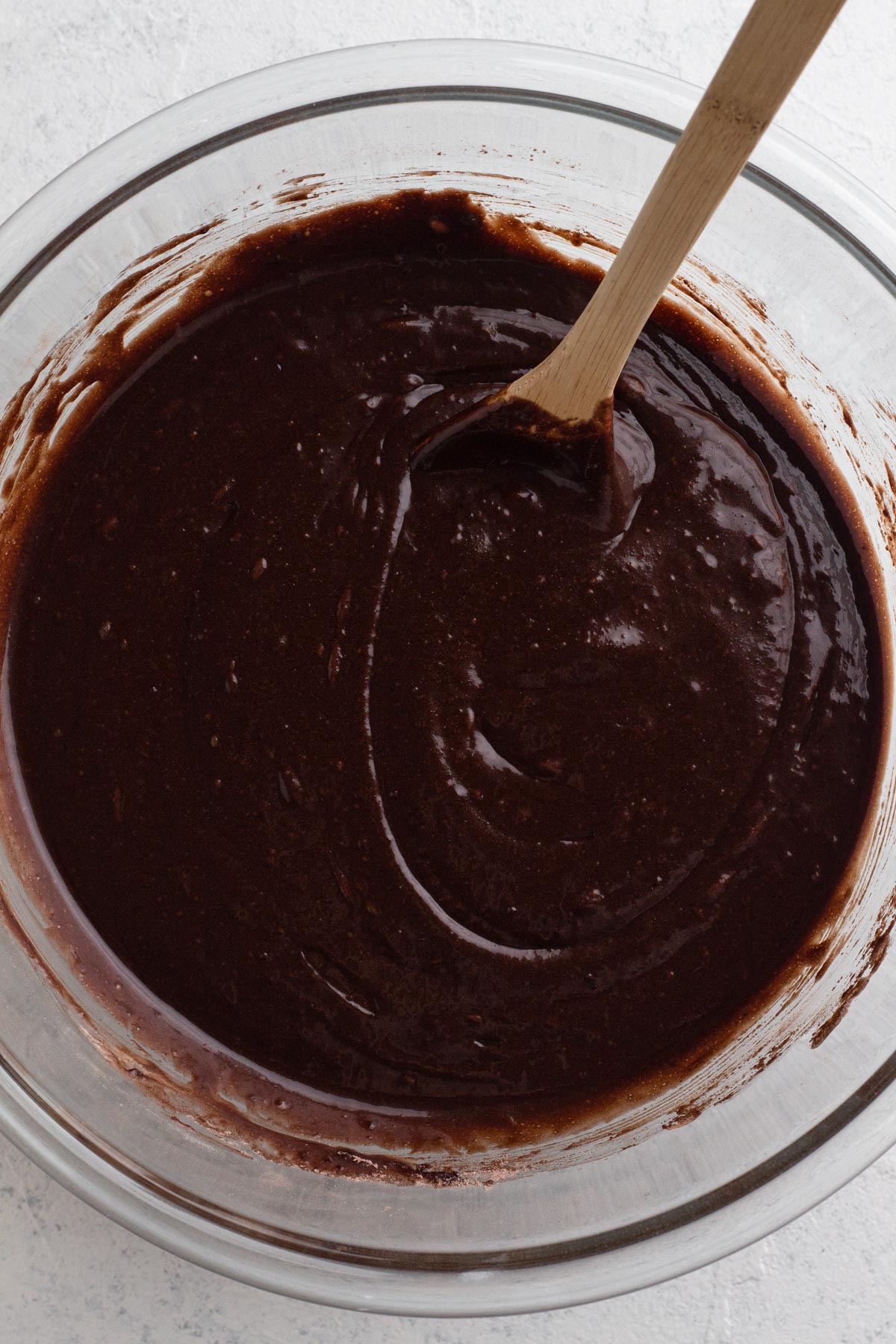 Chocolate cake batter in a glass mixing bowl.