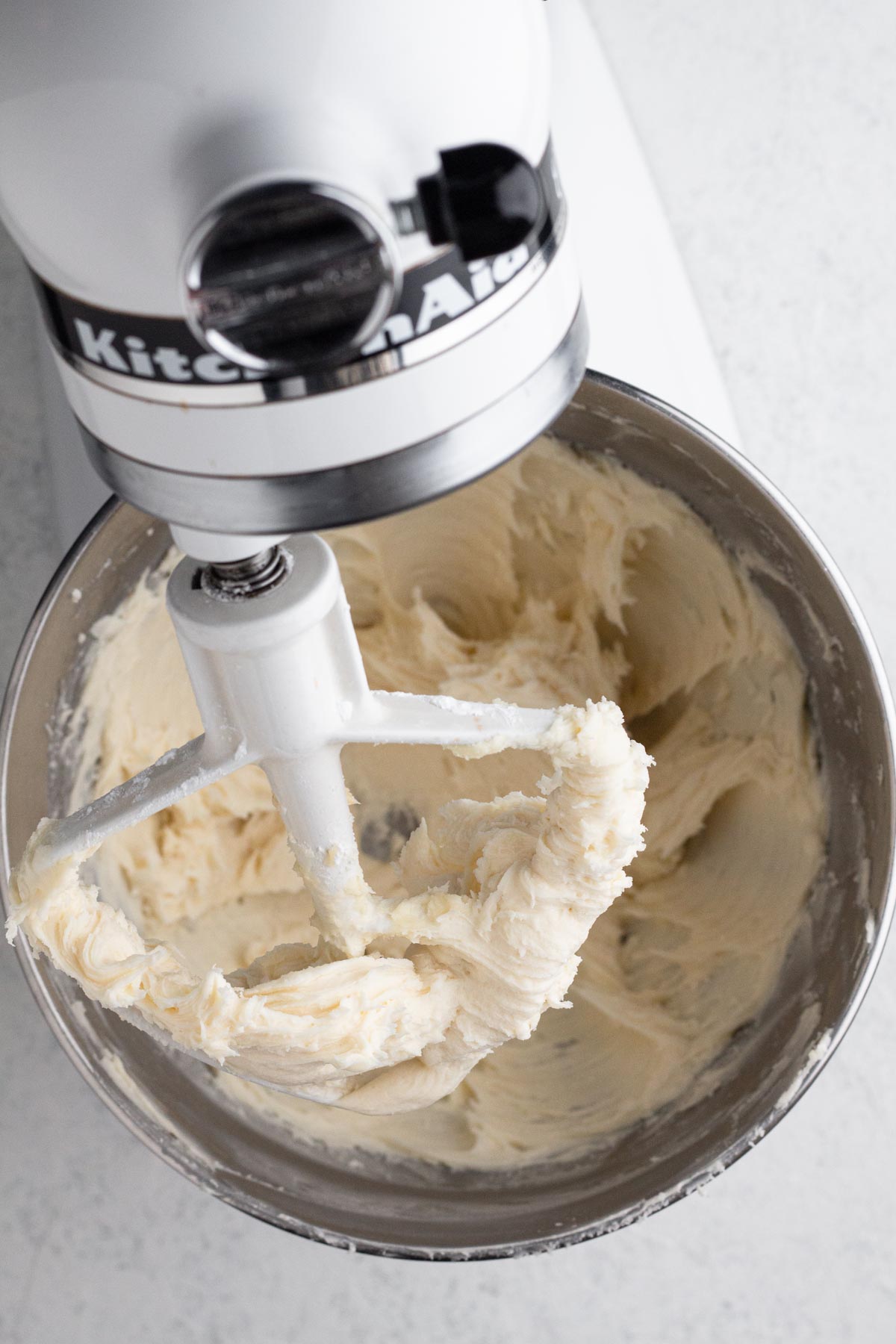 Vanilla frosting in the bowl of a stand mixer.