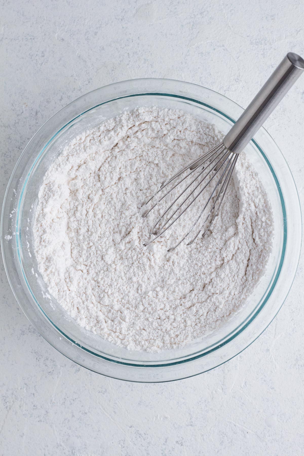 Dry ingredients whisked together in a glass mixing bowl.