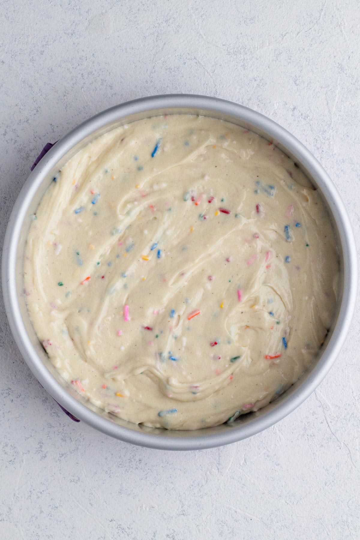 Cake batter in round cake pan.