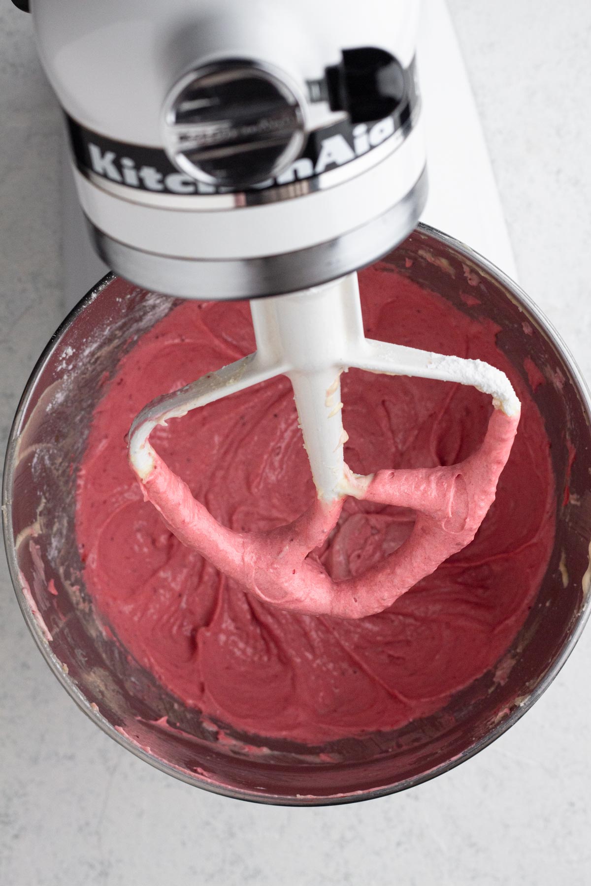 Strawberry cake batter in the bowl of a stand mixer.