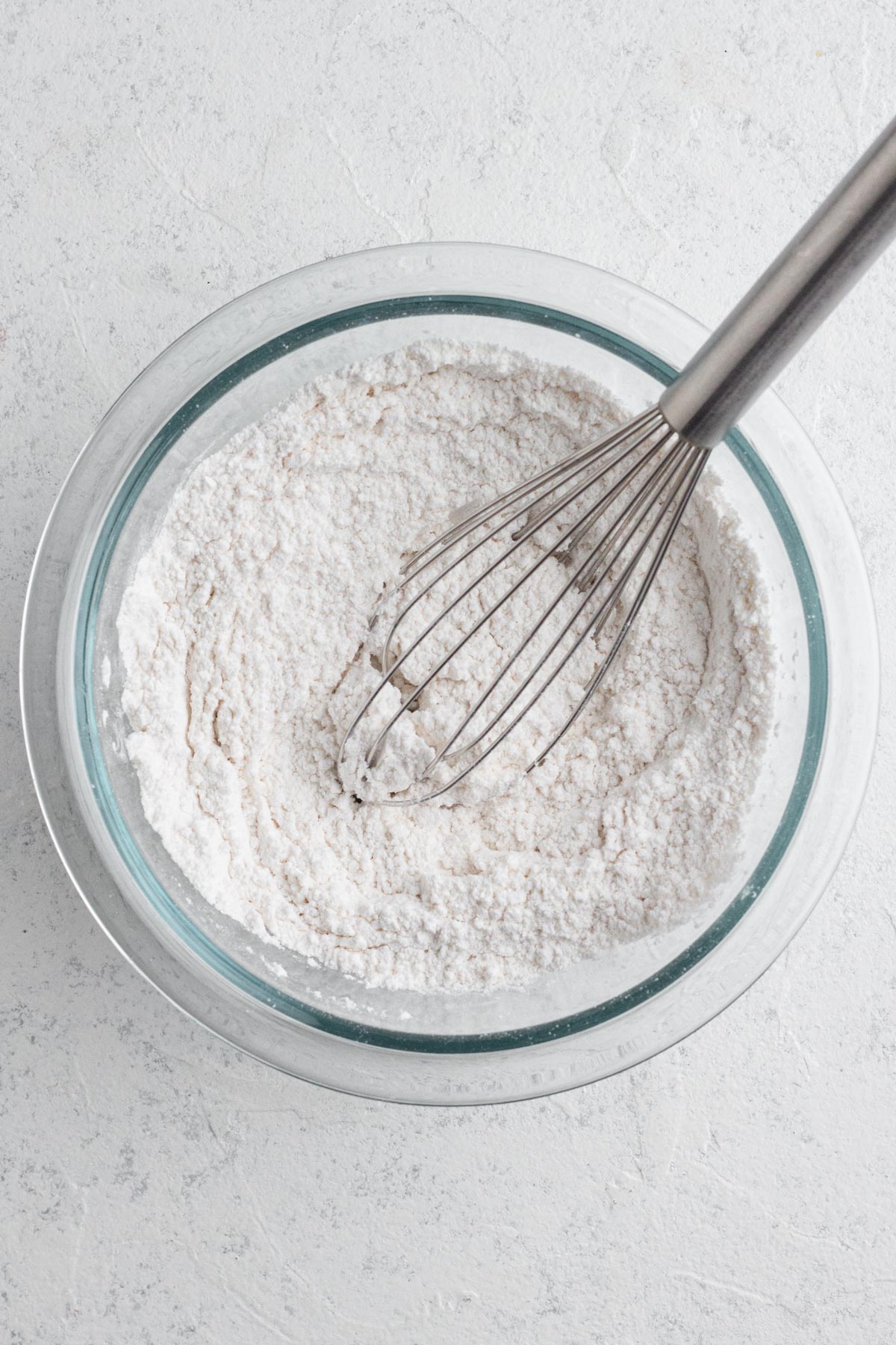 Dry ingredients whisked together in a glass mixing bowl.