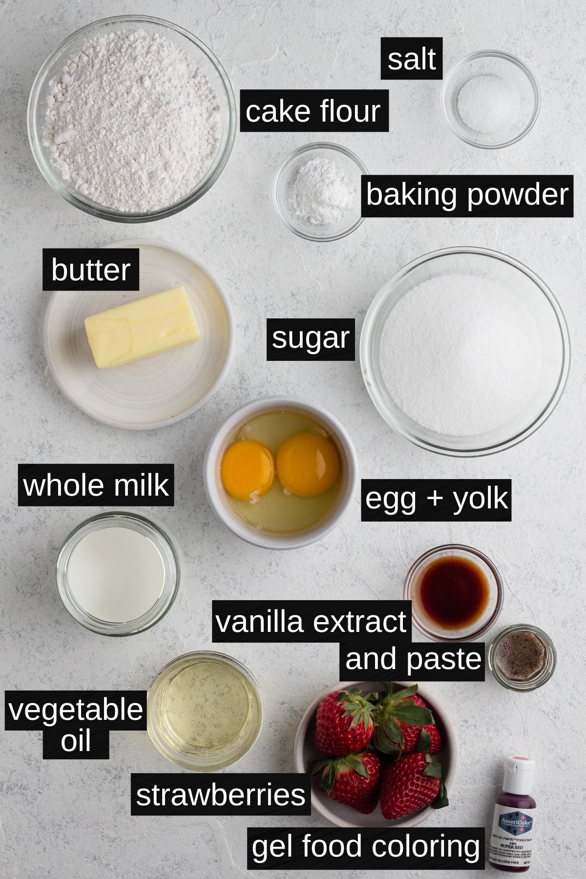 Vanilla and strawberry cake layer ingredients with labels on a white background.