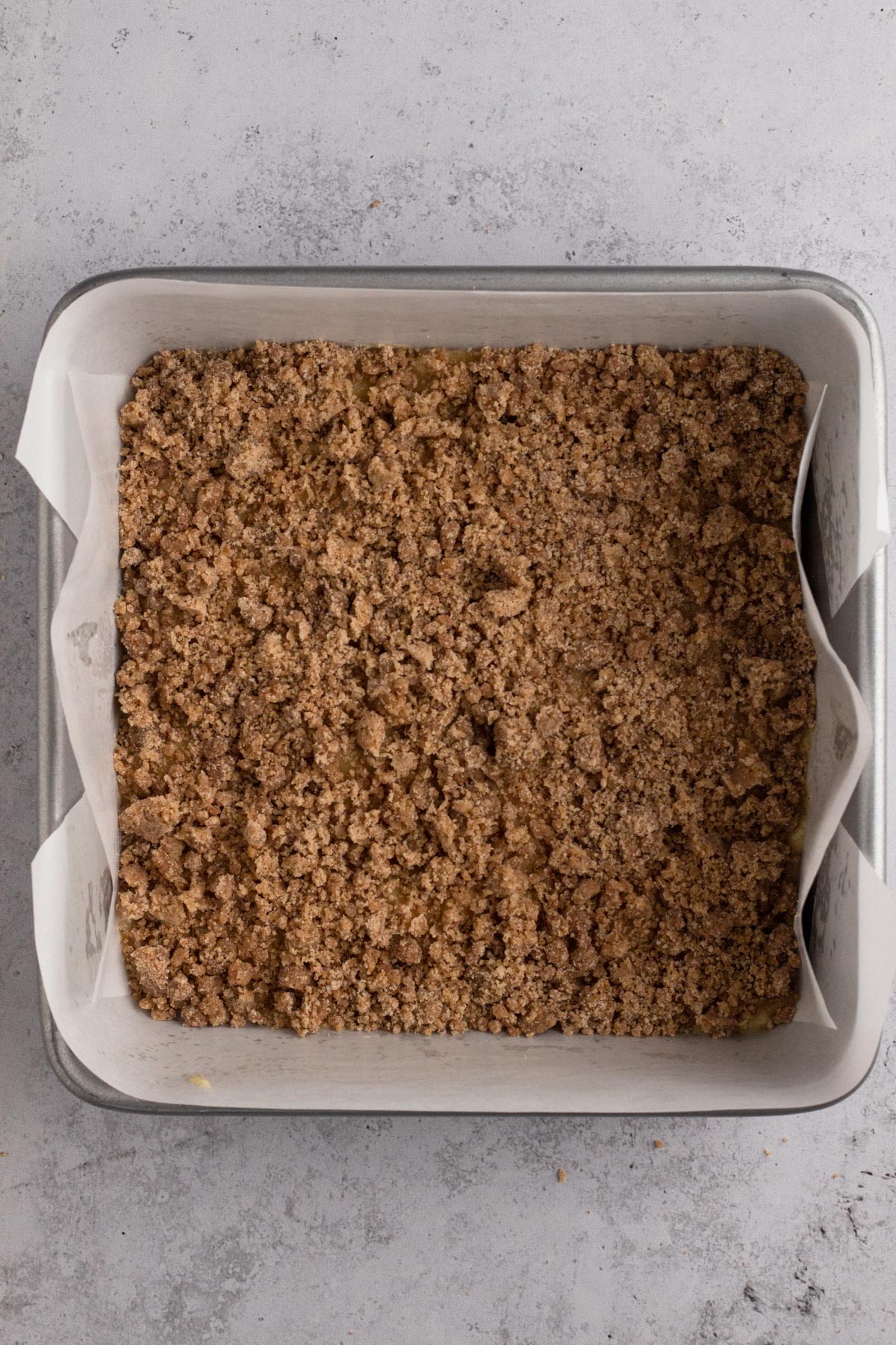 Cake batter and crumb filling in a square baking pan.