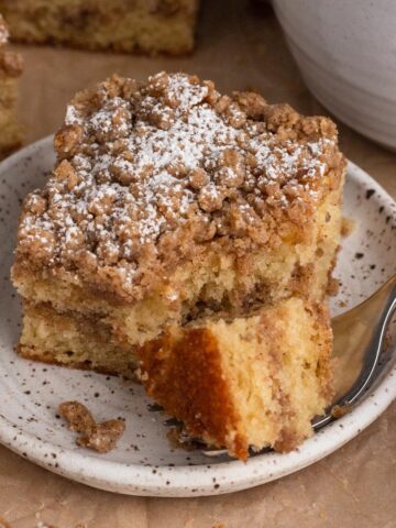 A slice and forkful of coffee cake on a speckled plate.